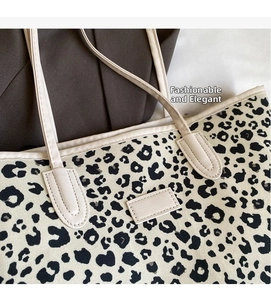 Gros plan sur un sac cabas en toile léopard avec bordure en cuir crème et étiquette rectangulaire