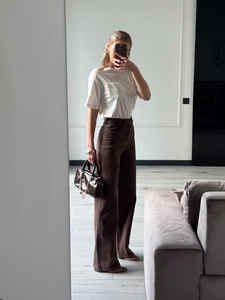 Women high waist wide leg brown denim jeans paired with white t-shirt and leather handbag