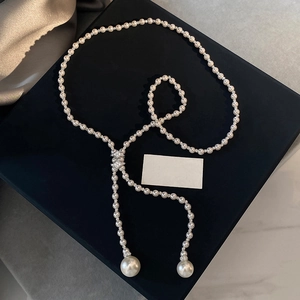 Elegant Y-shaped pearl necklace with zircon beads on a luxury dark jewelry box display