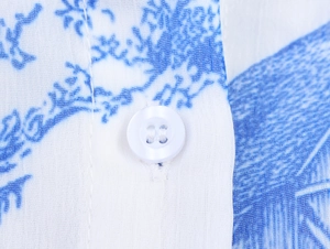 Nahaufnahme von atmungsaktivem blauem Blumenstoff mit weißem Vier-Loch-Knopf-Detail