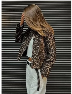 Vista laterale della giacca leopardata alla moda con bottoni neri e tasche