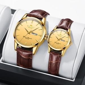 Detail of couple's gold quartz watches with brown leather straps and day-date display