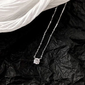 Macro shot of silver zircon pendant necklace with brilliant cut on elegant fabric