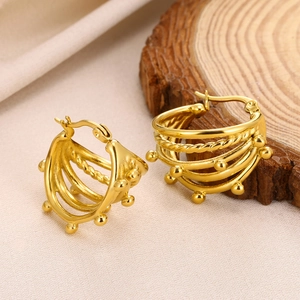Macro view of multi-layer hollow circular gold earrings on natural wood texture