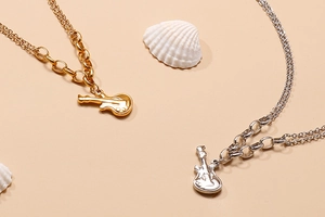 Detailed close-up of guitar pendants in gold and silver finish with seashell decor