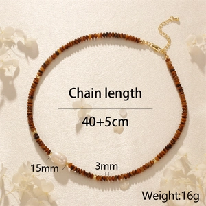 Flat lay of tiger eye bead necklace with 15mm baroque pearl and golden findings