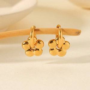 Elegant 18K gold plated stainless steel flower earrings hanging on a natural wooden branch