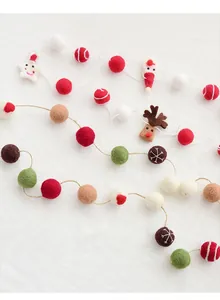 Macro view of handmade wool felt Christmas garland with Santa and reindeer ornaments