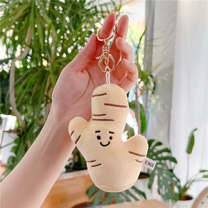 Cute ginger plush keychain held by hand, featuring embroidery face and golden clasp