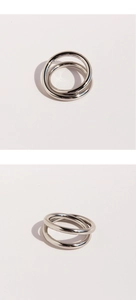 Detail of silver interlocking multi-layer cross lines ring with smooth metallic finish