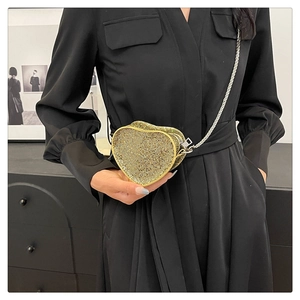 Detail of a sparkling gold heart-shaped sequin mini crossbody bag with a metal chain