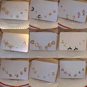 Detail of assorted stud earring set featuring star, moon, and cat designs on white cards