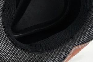 Detail of the black woven straw cowboy hat showing sweatband and leather strap stitching