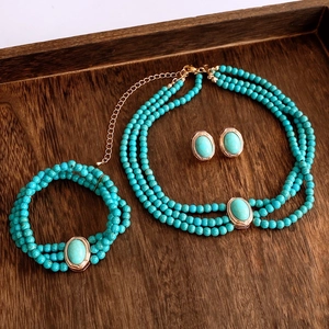 Détail de l'ensemble collier et bracelet multicouche en perles vertes sur plateau en bois