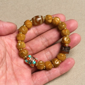 Detailed shot of ethnic agate bracelet with brown dZi beads and turquoise accents