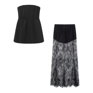 Dettaglio del completo nero a due pezzi con crop top a fascia e gonna lunga in pizzo