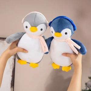 Close-up of cute stuffed penguins in gray and blue with tiny scarves and earmuffs