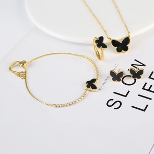 Detail of butterfly jewelry set featuring gold-black necklace, ring, bracelet and earrings