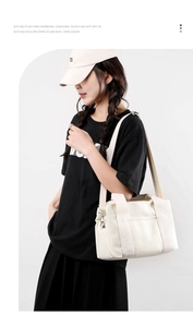 Detail of off-white canvas tote bag featuring adjustable shoulder strap and exterior pocket