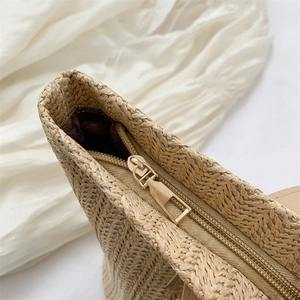 Straw bucket bag with a gold metal zipper and woven texture for summer beach vacation