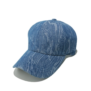 Detail shot of the blue denim striped texture and curved brim of the baseball cap