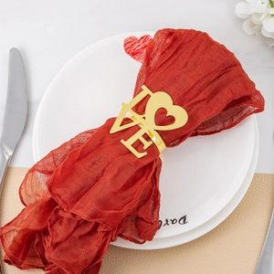 Golden heart and LOVE metal napkin ring styled on a red fabric napkin for Valentine's table