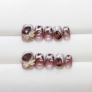 Burgundy cat eye press-on nails with leopard print, red gemstones and gold bows