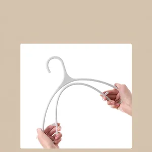 White PP plastic clothes hanger being flexed to demonstrate high toughness and durability