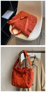 Close-up of quilted orange tote bag with diamond stitching and adjustable shoulder strap
