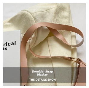 Detail of adjustable strap and gold metal hardware on nude pink leather handbag
