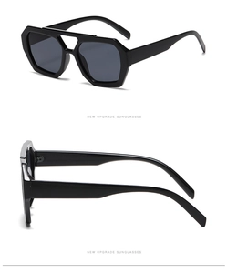 Detail view of black double-bridge geometric sunglasses with hexagonal frames and glossy finish