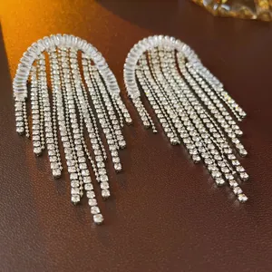 Elegant silver tassel earrings with geometric zirconia crystals on a luxury leather surface