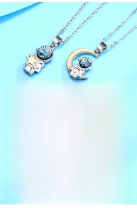 Detail of silver and gold plated astronaut couple necklaces with star and moon charms
