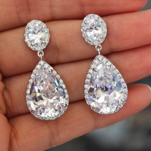 Macro detail of pear-shaped halo earrings with AAA zircon stones and silver plating