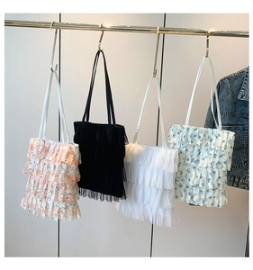Detail of colorful ruffled lace tote bags with floral patterns and tiered mesh layers