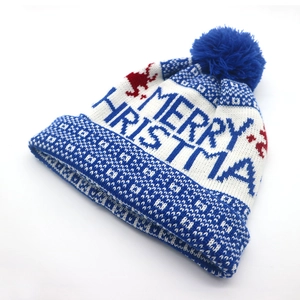 Detail view of the Merry Christmas lettering on the blue and white knitted festive hat