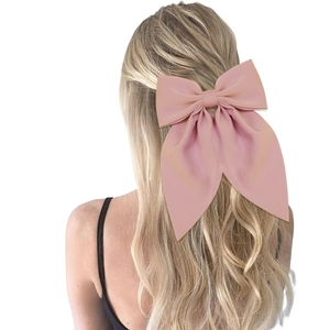 Pink satin large bow hair clip for women shown on a model for a sweet daily look