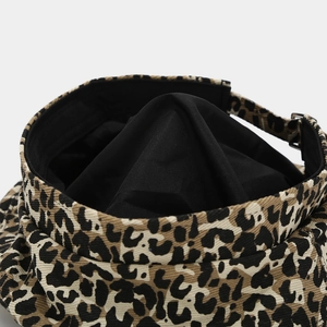 Detail of leopard print beret featuring adjustable buckle strap and black inner lining