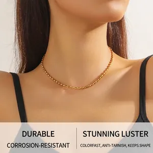 Close-up of polished gold-plated stainless steel ball chain necklace on model