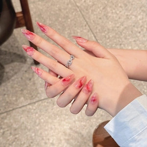 Handmade almond press-on nails with red marble gradient design and semi-transparent finish