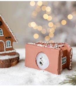 Detail of miniature gingerbread house base showing the battery slot and power switch
