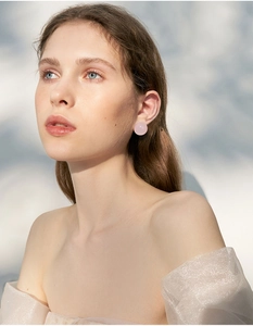 Elegant model wearing pink round stud earrings with premium S925 silver needle design