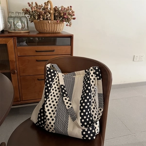 Dettaglio ravvicinato della borsa tote in tela a pois con etichetta tessuta Simple Wish