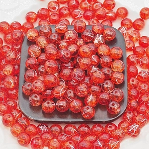 Close-up of 10mm red cracked glass beads with gold wire detail for DIY jewelry making