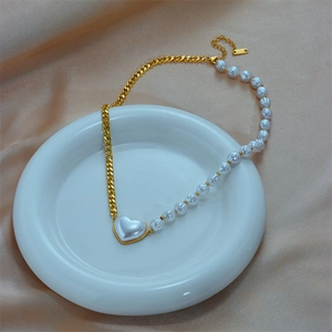 Chic gold chain and pearl necklace with a pearl-inlaid heart pendant on champagne silk