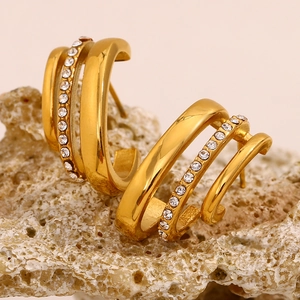 Detail of 18K gold plated flag style stud earrings with cubic zirconia on a rock