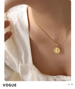 Close-up of a vintage French gold coin pendant necklace featuring a queen relief on model