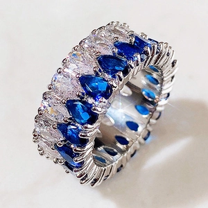 Vue macro de deux rangées de saphirs bleus taille poire et émeraude sur anneau argent
