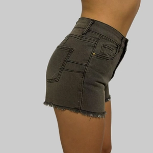 Detail view of high waisted denim shorts with frayed hems and slim fit design