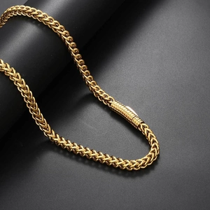 Macro detail of 6mm golden franco chain necklace wrapped on a black jewelry stand
